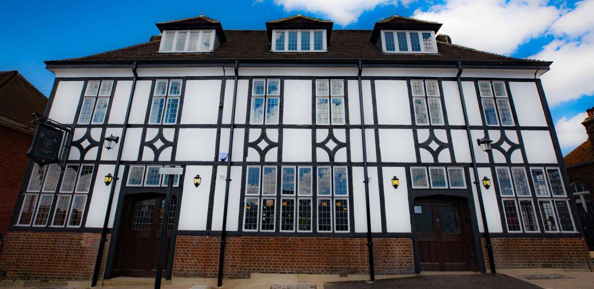 Mock-Tudor exterior facade of The Fellowship Inn pub location in Lewisham SE6 through Love Locations, showing dark timber framing and white render