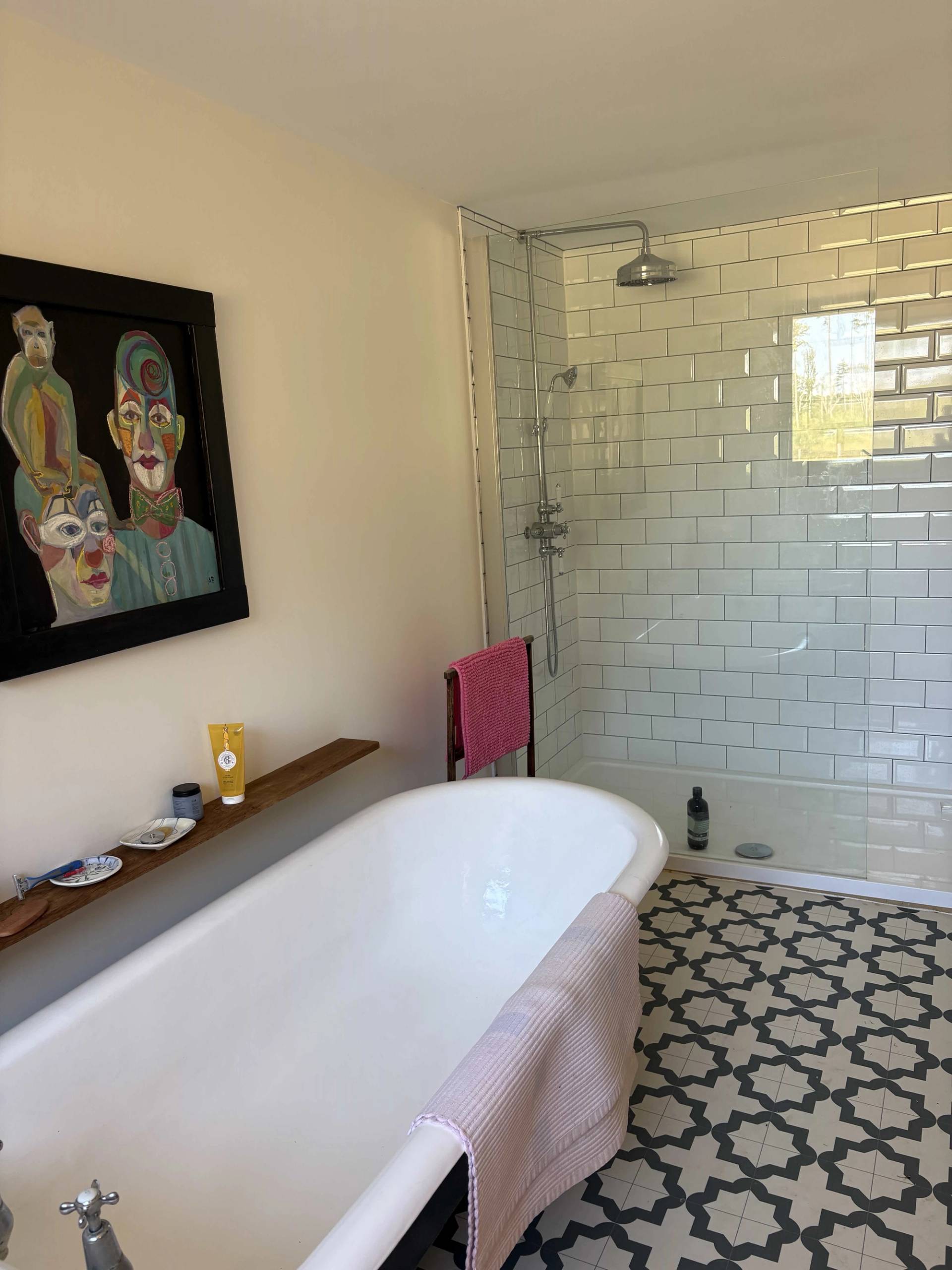 Roll-top clawfoot bathtub set beside a tiled walk-in shower enclosure in a rustic farm cottage, Love Locations BN8.
