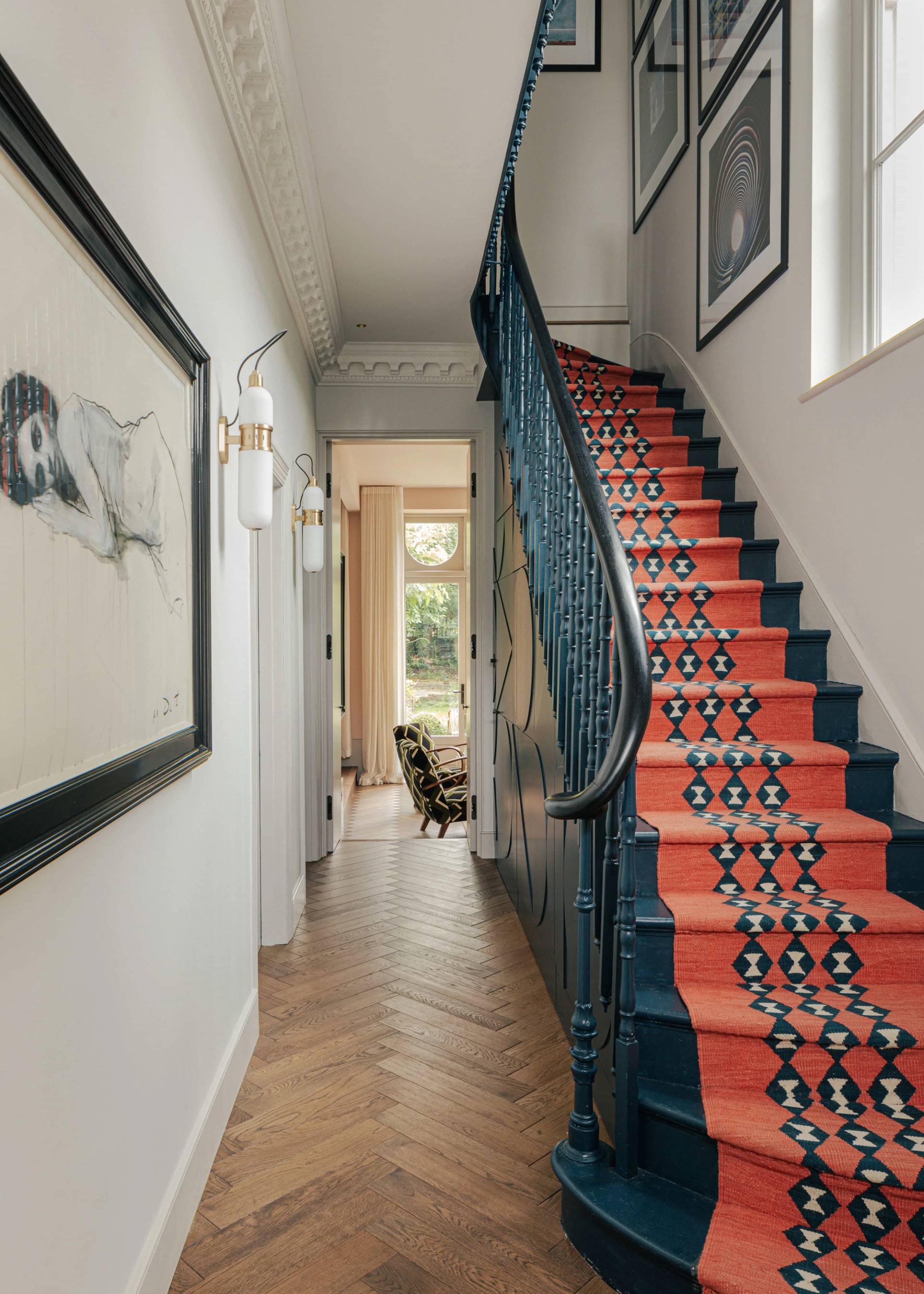 Grand Victorian entrance hallway featuring herringbone parquet floors and a dark staircase with a red patterned runner, ideal for film establishing scenes, Love Locations.