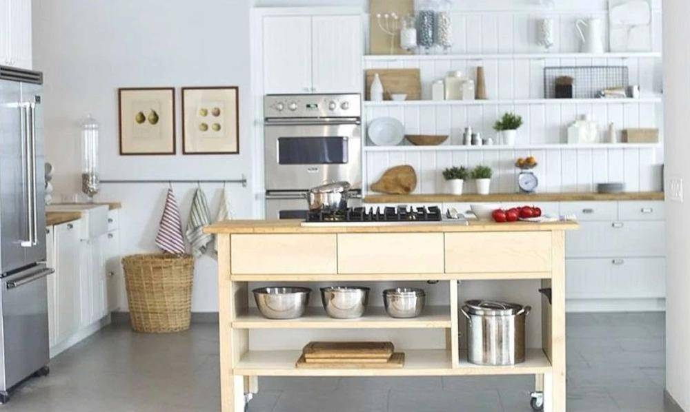 Modern mobile kitchen island with stainless steel appliances and open shelving inside a bright NYC studio, ideal for commercial cooking shows, Love Locations.