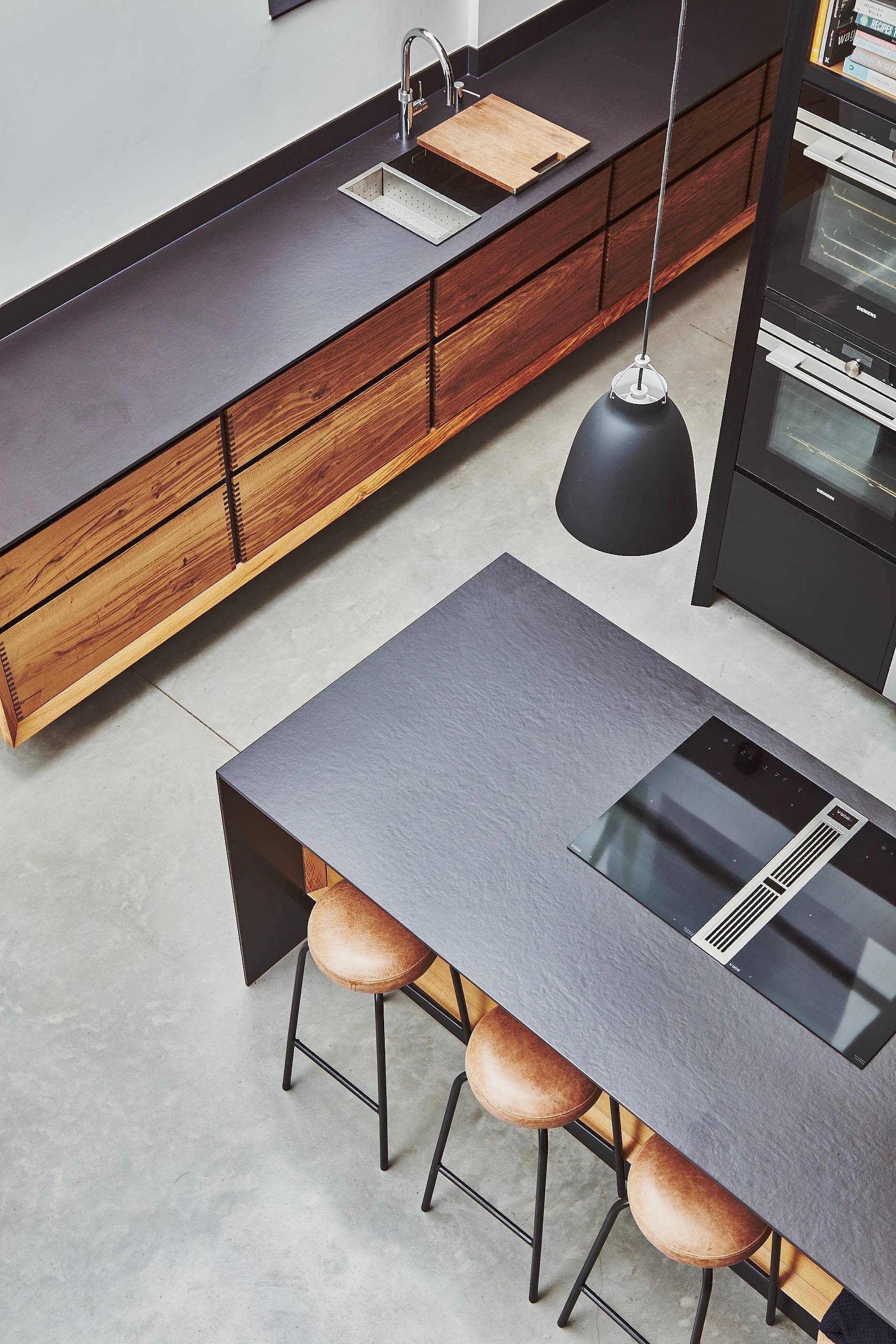Top-down kitchen view showing a dark grey prep island and wooden counter storage, Love Locations TW1.