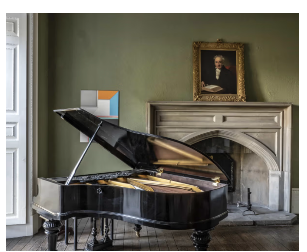 Grand piano positioned in a heritage reception room at Keythorpe Hall with green walls, original fireplace and period architectural features.