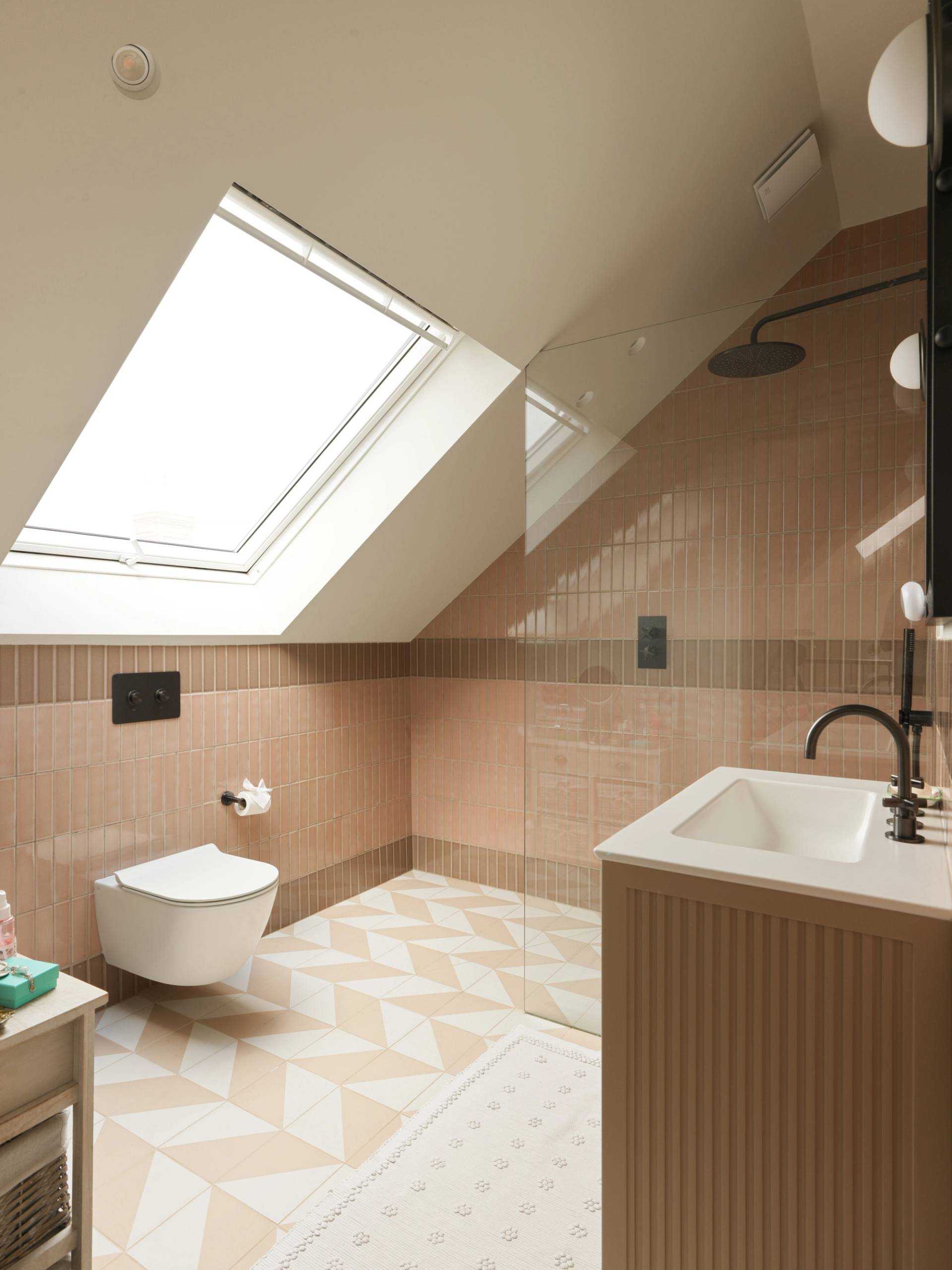 Modern attic bathroom filming space featuring a skylight window, wall-hung toilet, and patterned tiled floor through Love Locations.
