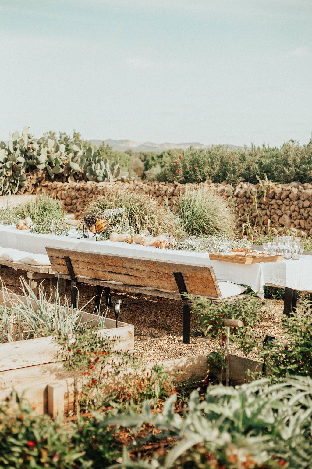 Al fresco dining setup on a stone terrace set amidst Mediterranean garden flora, Love Locations 07630.