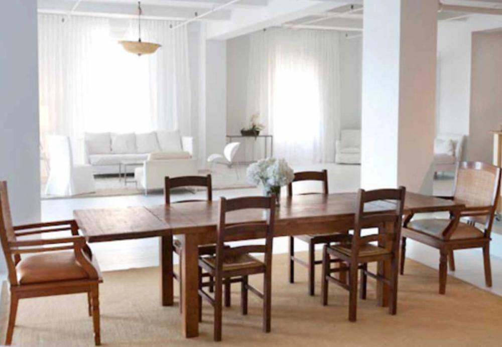 Large rustic wooden dining table and chairs set inside a bright loft studio space, perfect for family dining commercials and editorial content, Love Locations NYC.