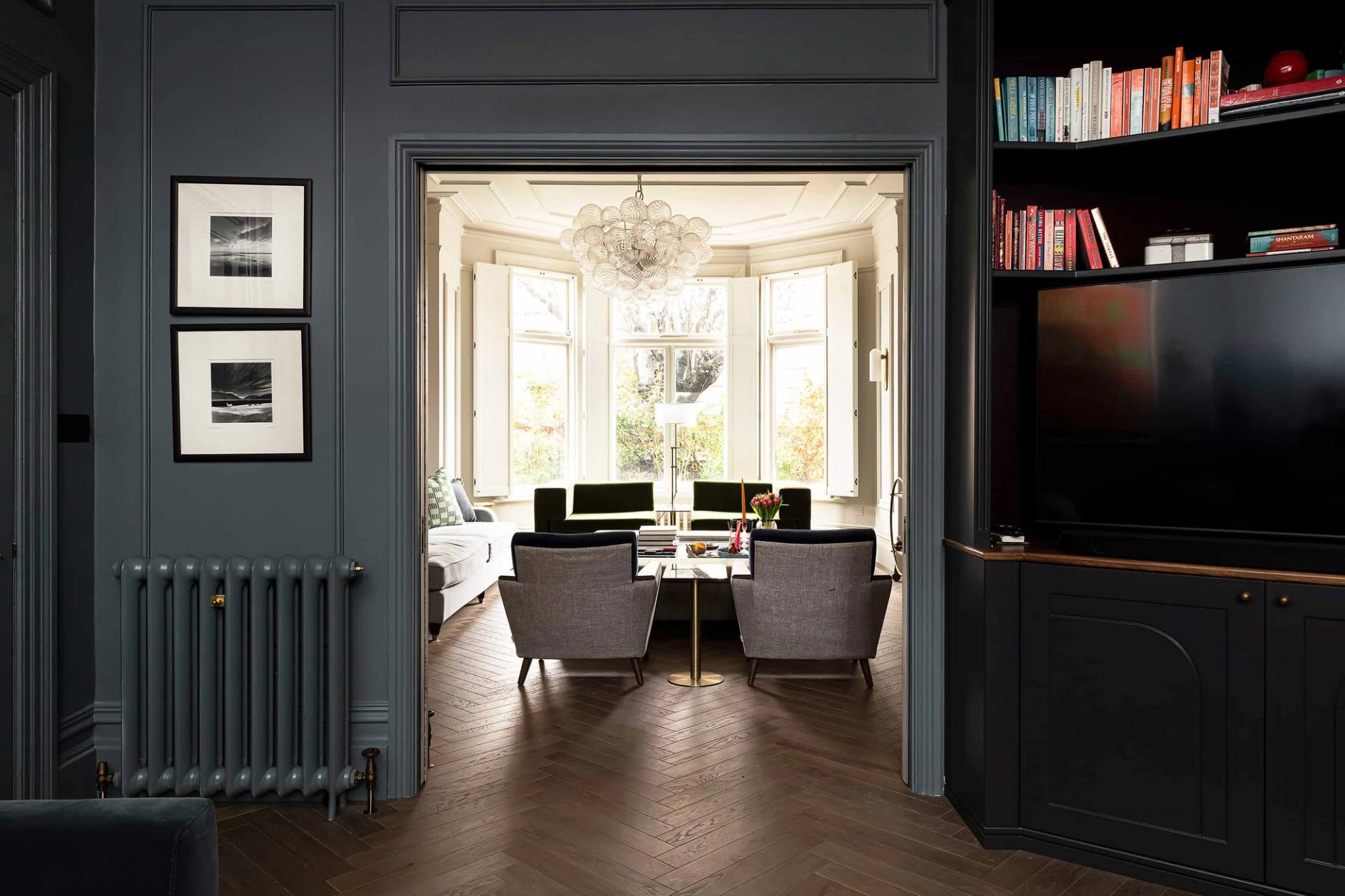 Looking from a dark blue snug room back into a light-filled bay-windowed formal living room, ideal for commercial film backdrops, Love Locations.