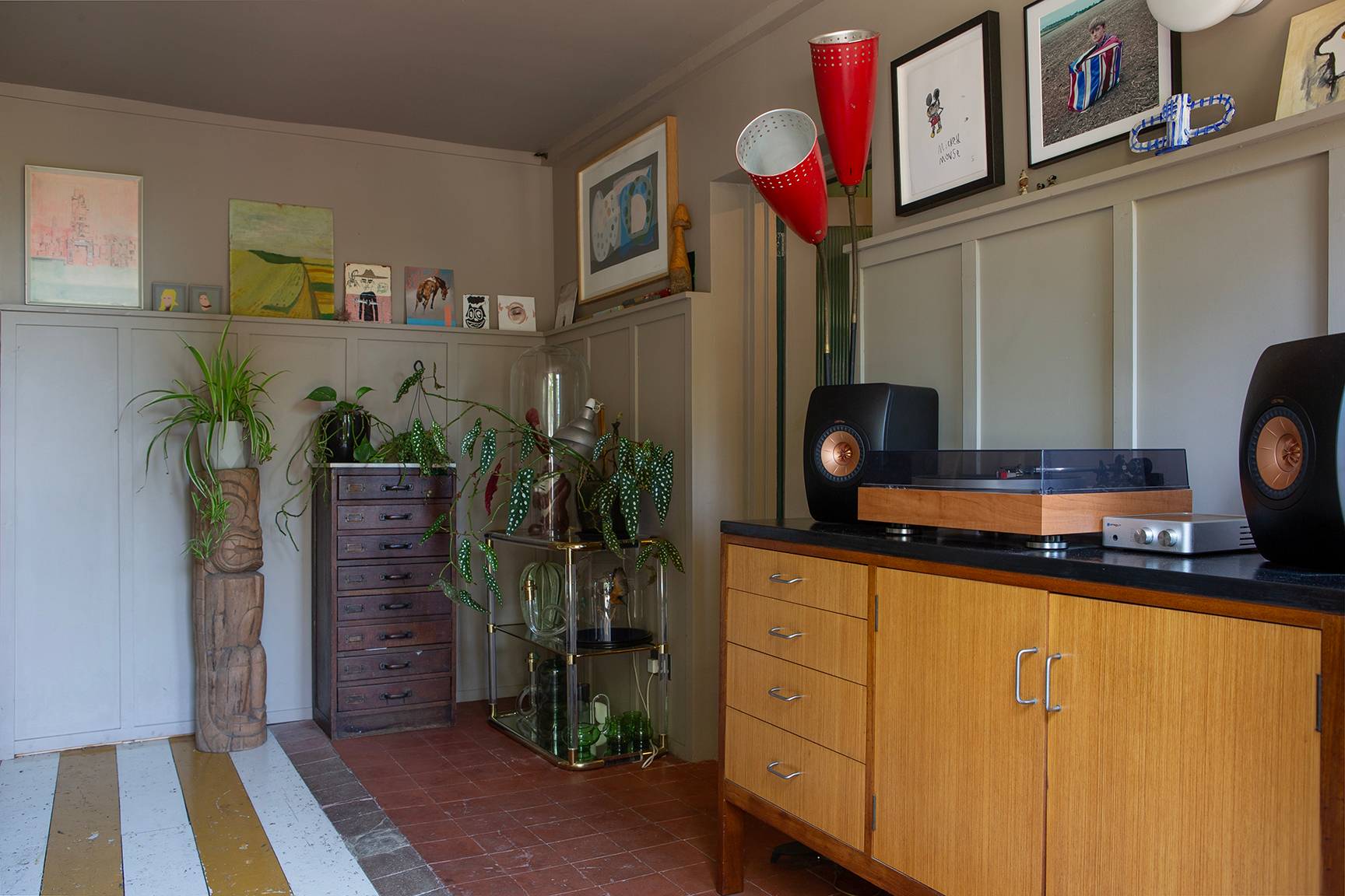 Wood panelled corridor nook with a wooden sideboard, red table lamps, and potted floor plants, Love Locations ME13.