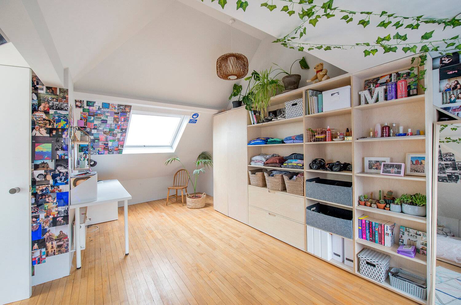 Attic bedroom suite featuring bespoke Birch plywood storage shelving, sloped ceiling skylights, and light wood flooring, Love Locations Forest Hill.