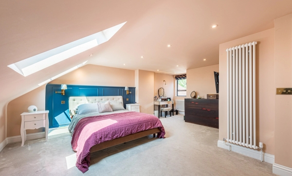 Spacious attic bedroom location room with neutral carpets and vibrant bedding for lifestyle photography shoots, Love Locations N11.