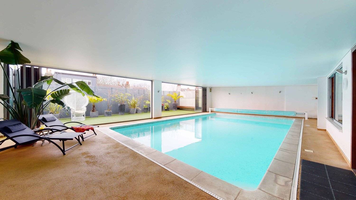Private indoor heated swimming pool shoot location in Streatham, SW16 featuring turquoise water, stone coping, and large windows, Love Locations.