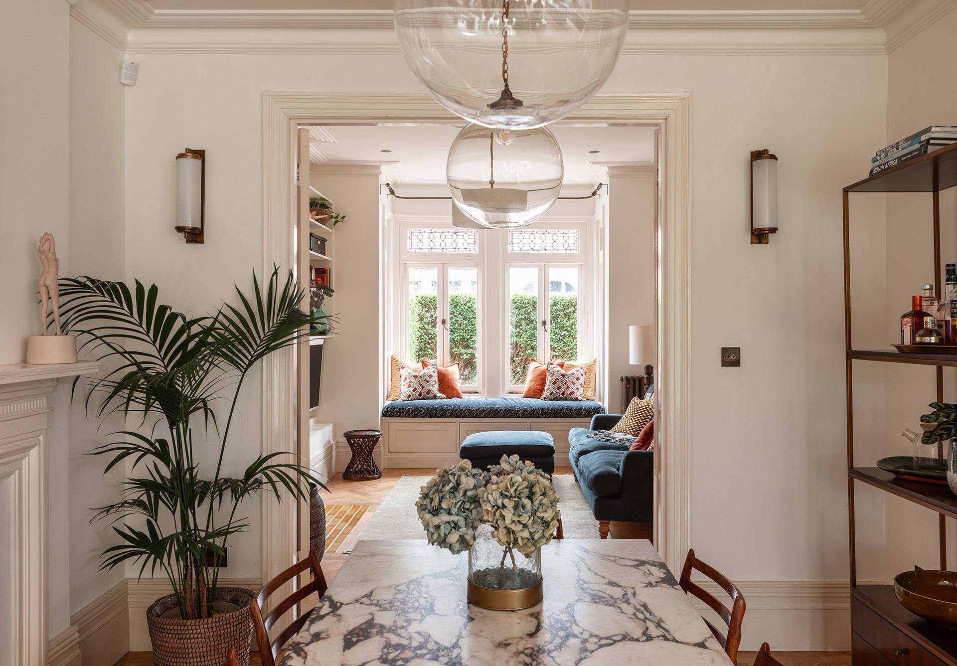 Wide perspective of a light dining room framed by elegant wall mouldings and pendant globes, ideal for high-fashion brand shoots, Love Locations TW1.