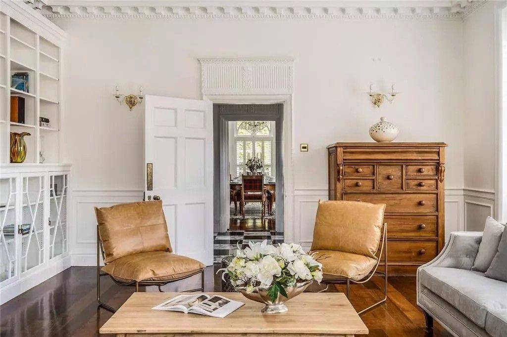 Elegant reception room seating nook with tan leather armchairs, wooden coffee table, and classical double doorway in Reading RG10 from Love Locations.