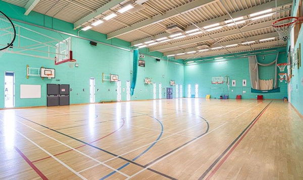 Love Locations indoor gymnasium film location London SE2: Sprawling physical education hall with professional overhead lighting grids, tailored for athletic training videos and film shoots.