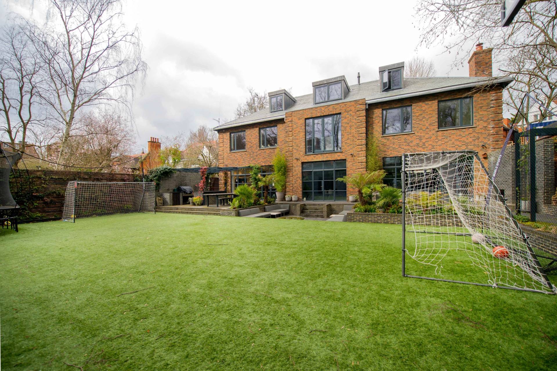 Spacious private back garden and lawn area framed by a classic London townhouse exterior, ideal for outdoor brand shoots, Love Locations NW3.