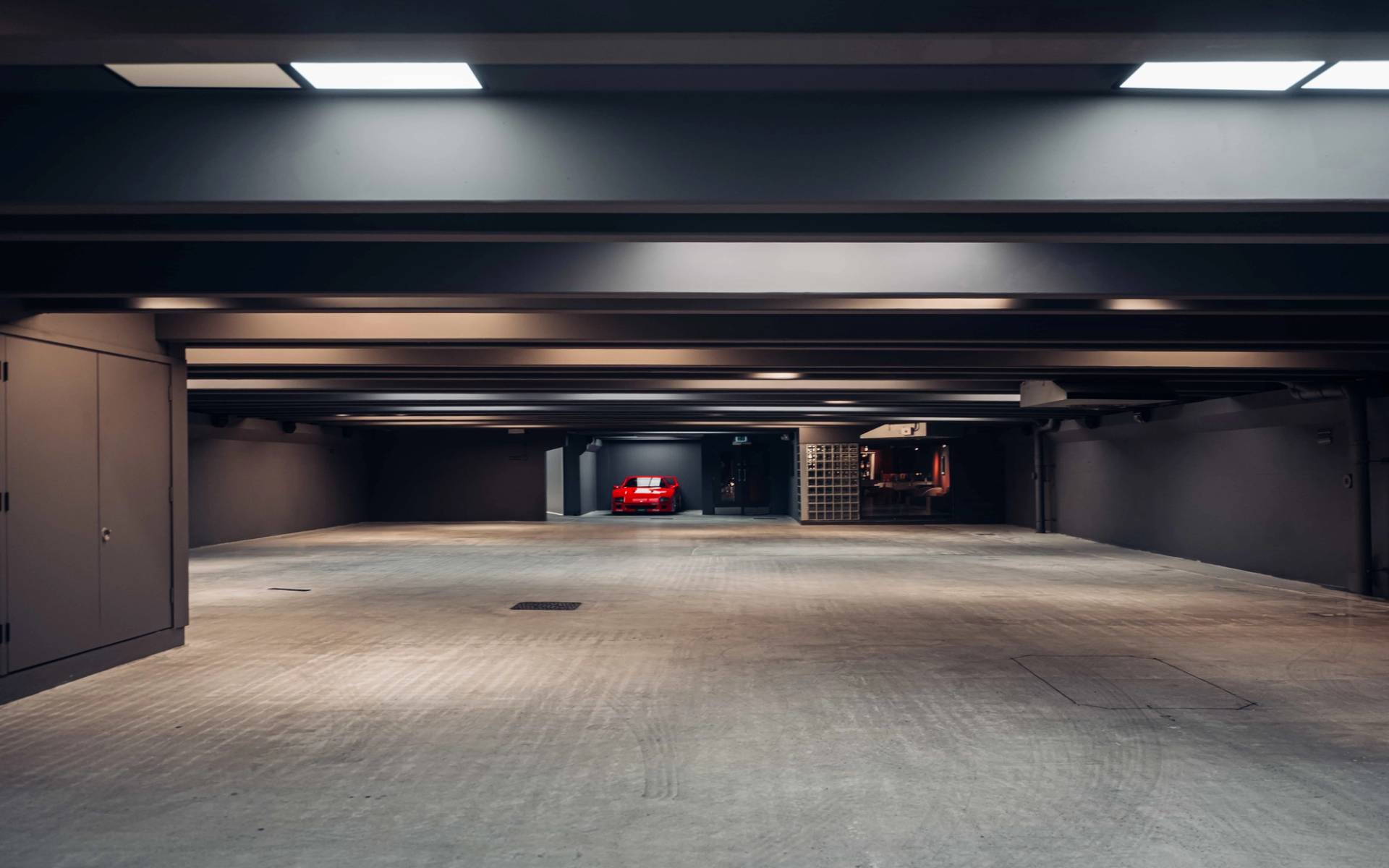 Minimalist underground garage and bunker shoot space in Brentford TW8 by Love Locations, featuring overhead light panels and concrete finishes.