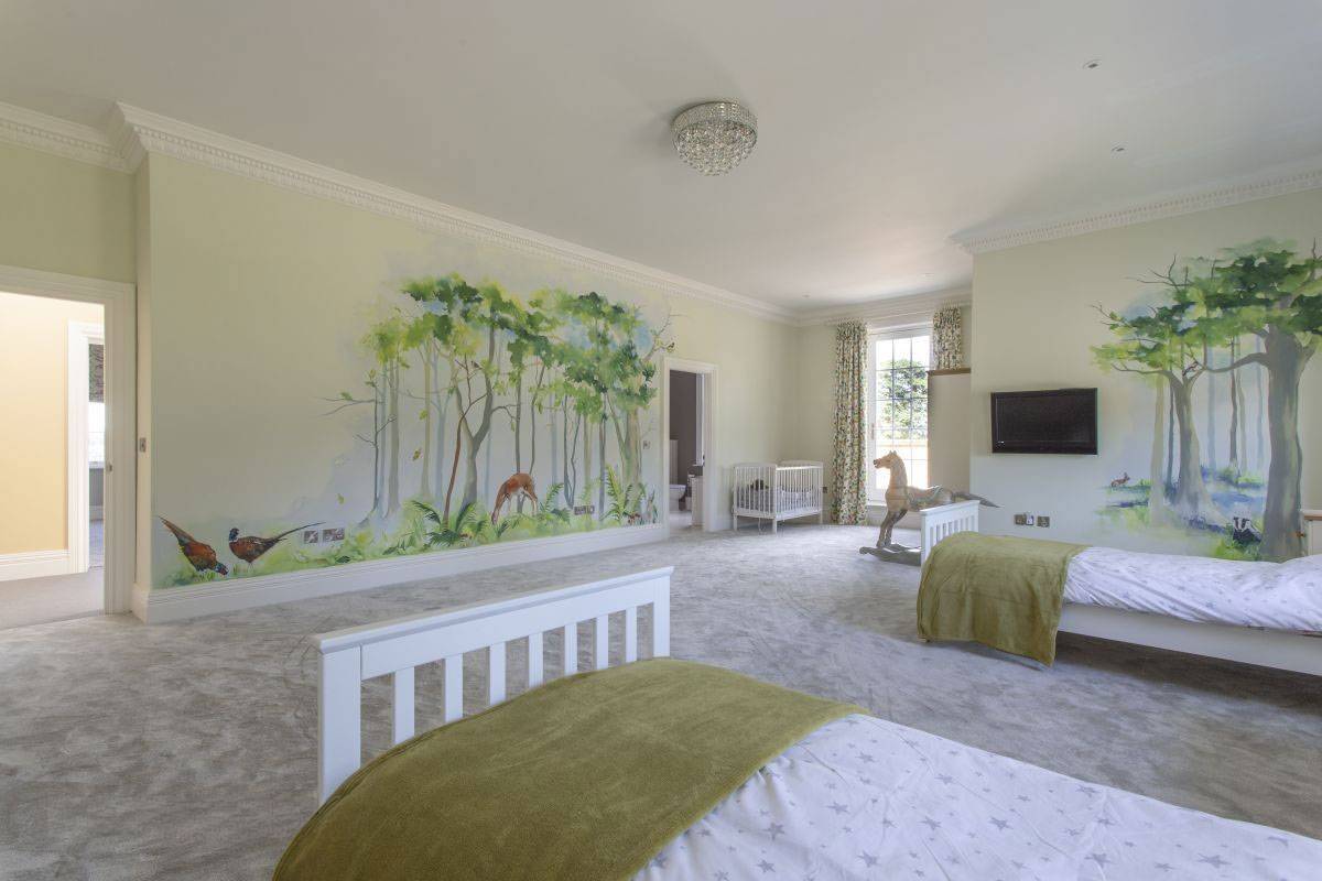 Beautifully styled bedroom with green woodland wall mural, ideal for editorial lifestyle photography, Love Locations property hire.