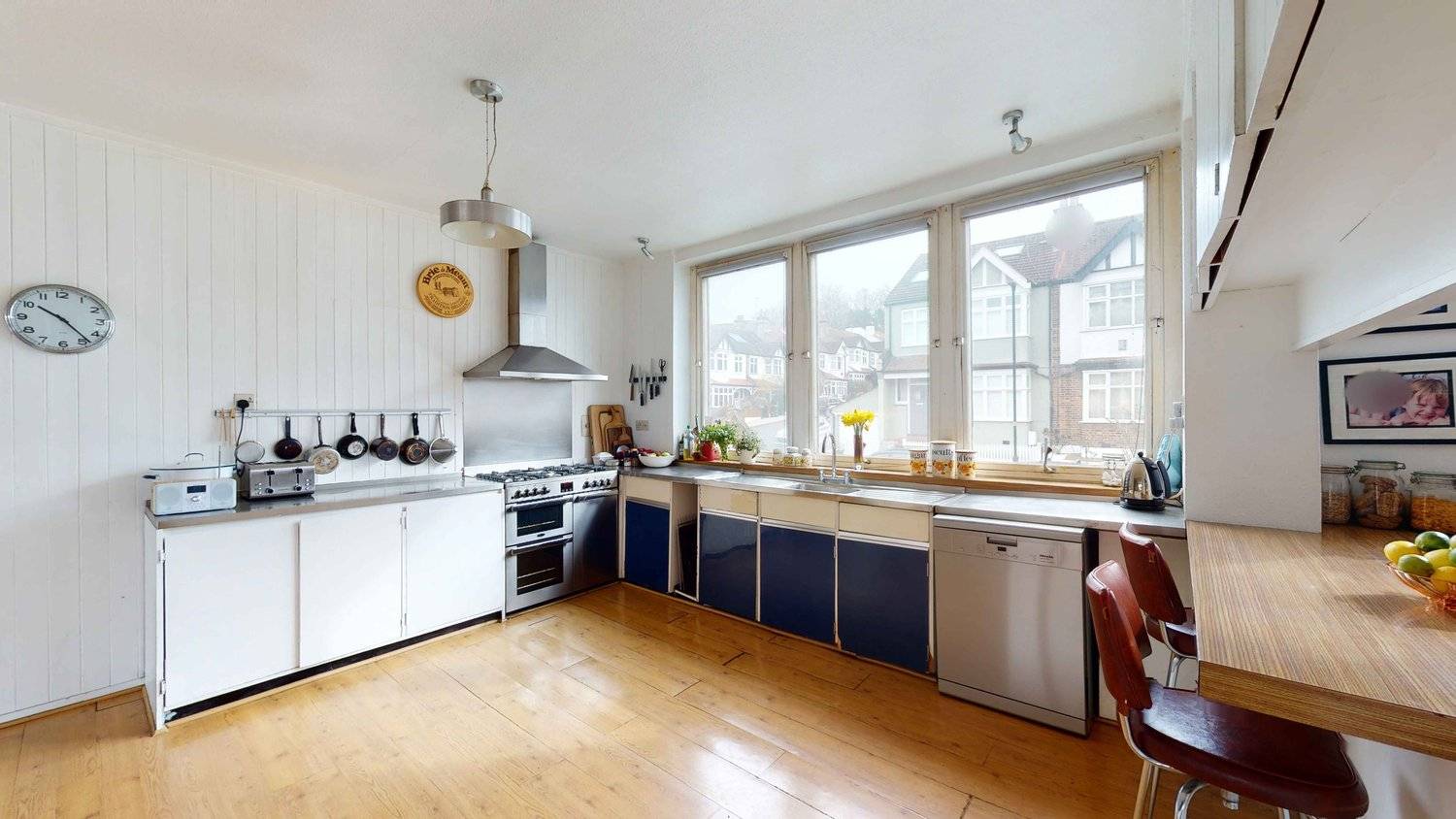 Vintage 70s kitchen with stainless steel gas range cooker, blue cabinets, and timber ceiling cladding, ideal for period film scenes, Love Locations SW16.