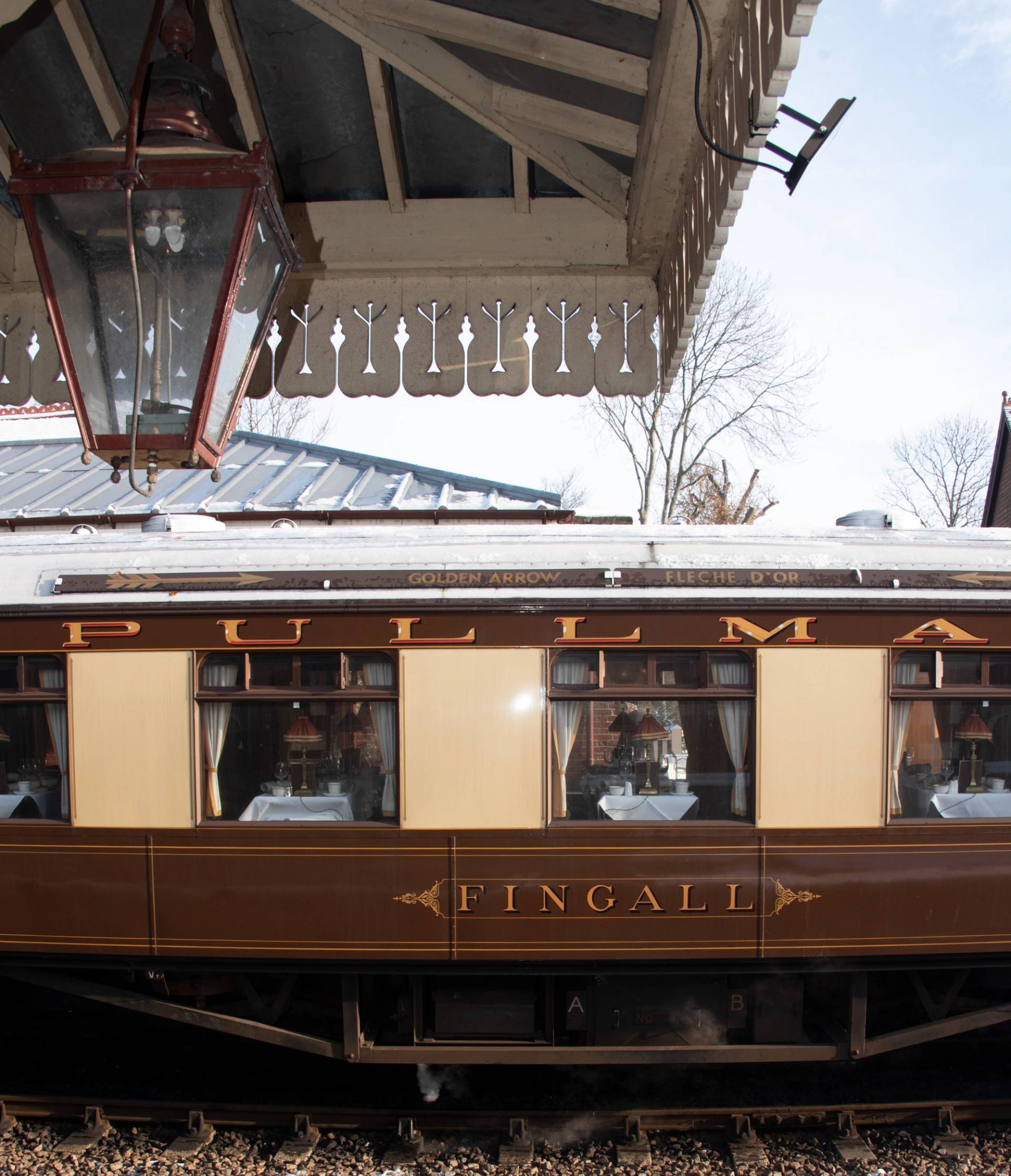Vintage Pullman train carriage "Fingall" stationary under a station platform canopy in Sheffield Park, ideal for historical filming, Love Locations.