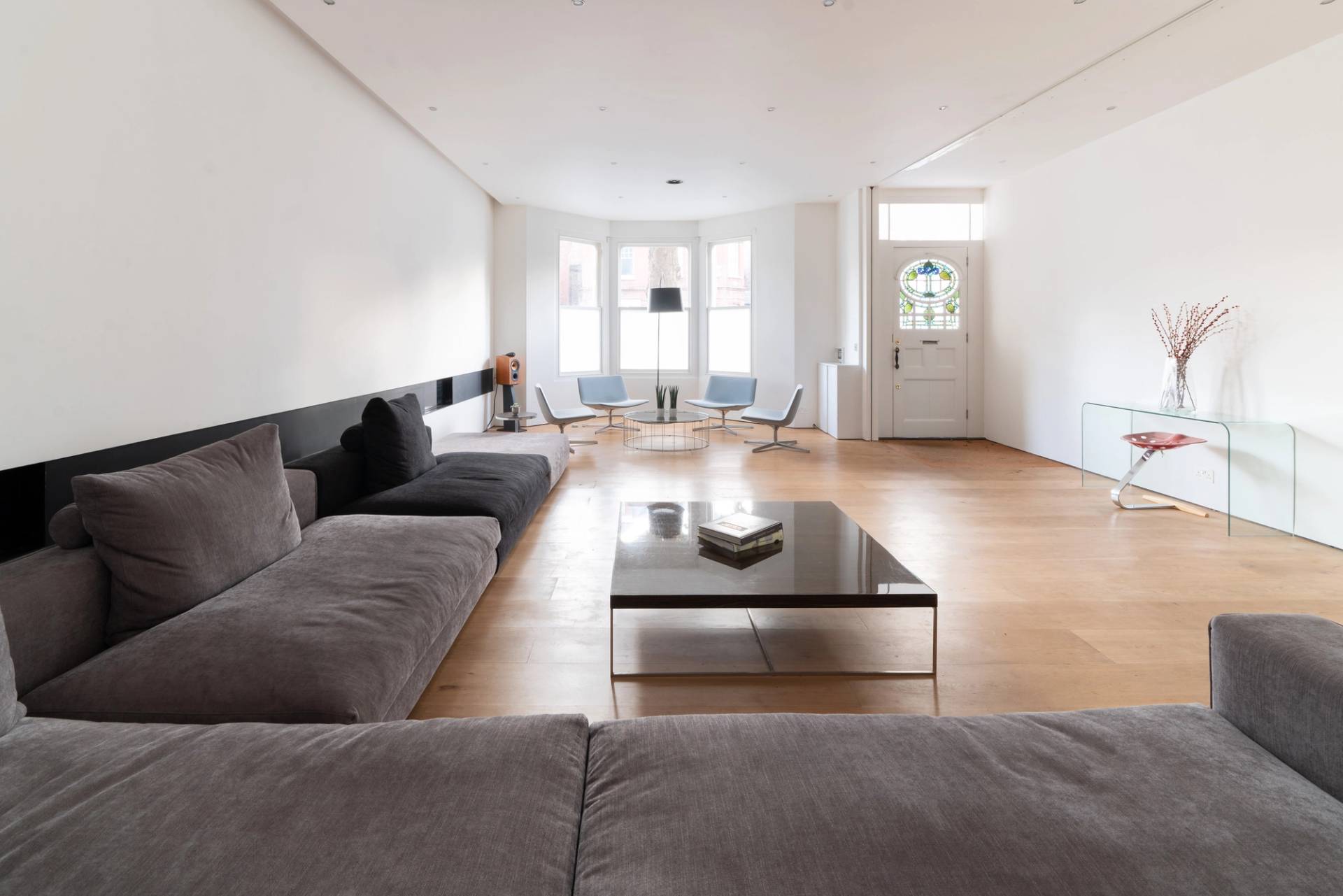 Modern converted Victorian house shoot location in Fulham, SW6 featuring an expansive open-plan reception room with L-shaped corner sofa and wood flooring via Love Locations.