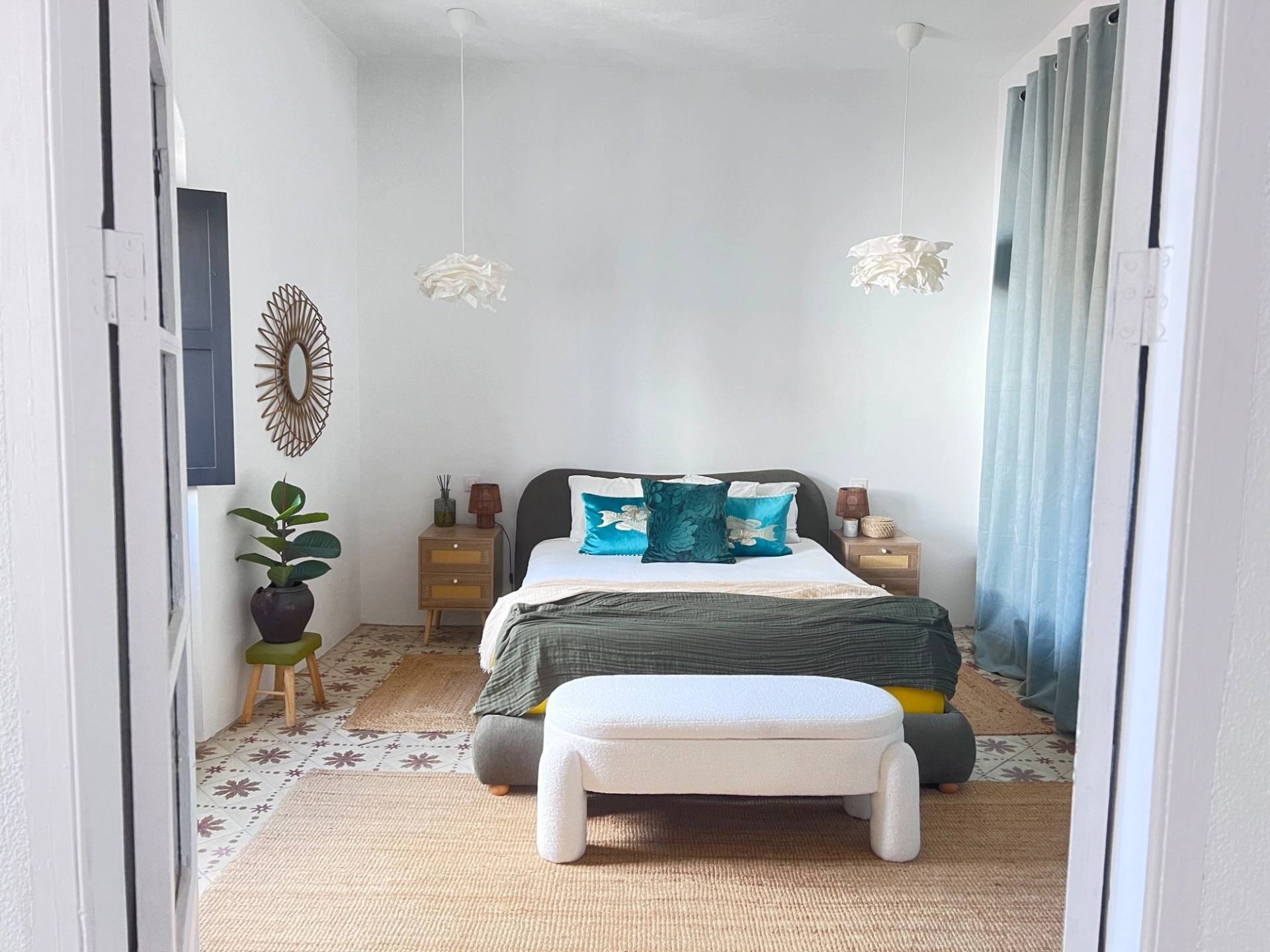 Serene master bedroom shoot location in Jimena de la Frontera Cádiz from Love Locations, featuring a white bed bench, soft curtains, and Spanish patterned floor tiles.