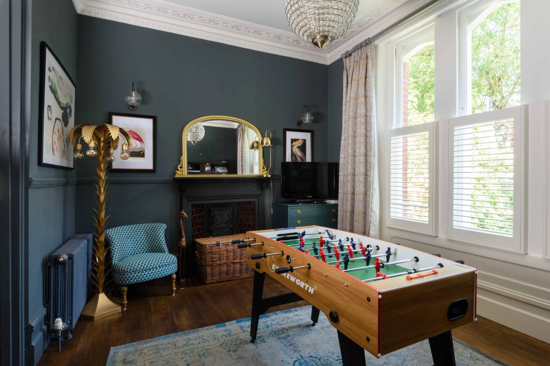 Games room suite featuring a football foosball table, dark blue walls, gold mirror, and sash window, Love Locations TW11.