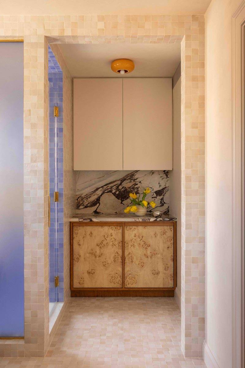 Custom vanity and mirror nook shoot space in a Boerum Hill townhouse location house from Love Locations, with textured marble tile and clean light wood cabinetry.