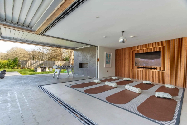 Love Locations home wellness shoot location GU8: Dedicated yoga and pilates studio room with exercise mats aligned toward sliding glass doors, perfect for health and wellness branding.