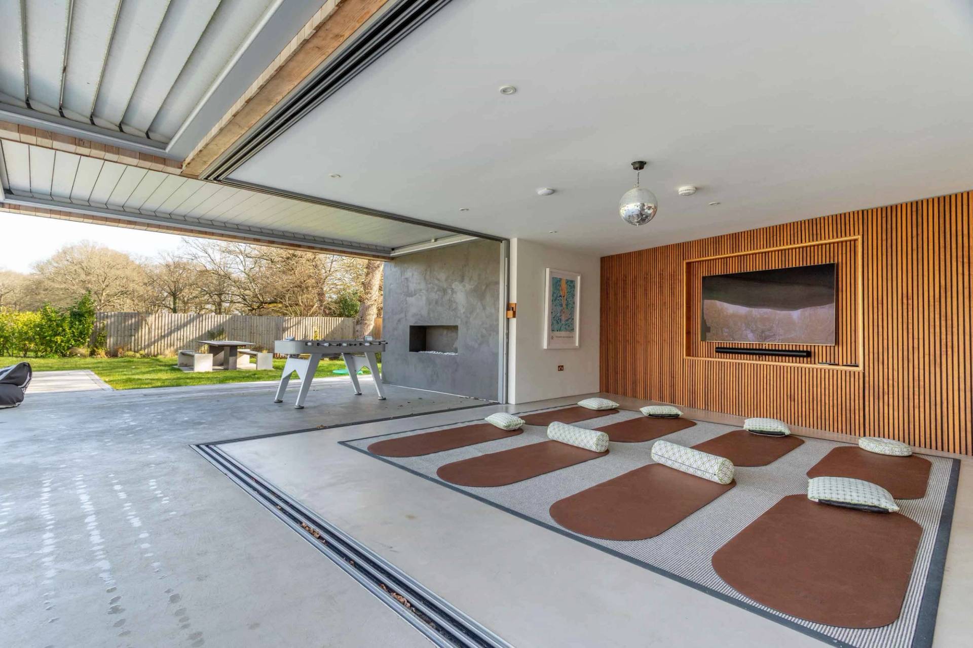Love Locations home wellness shoot location GU8: Dedicated yoga and pilates studio room with exercise mats aligned toward sliding glass doors, perfect for health and wellness branding.