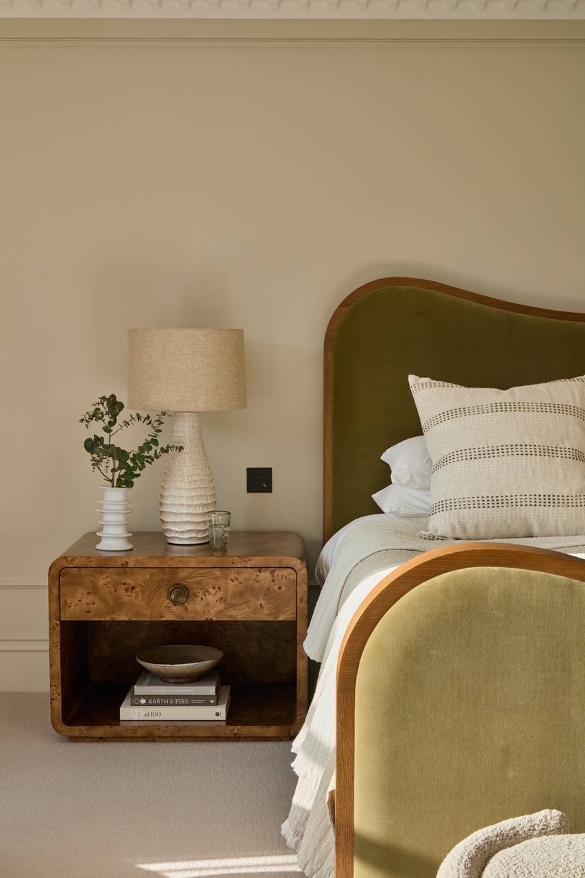 Chic bedside setup showing a fluted timber nightstand, a contemporary ceramic lamp, and elegant olive green textures, suitable for boutique hotel-style shoots, Love Locations.