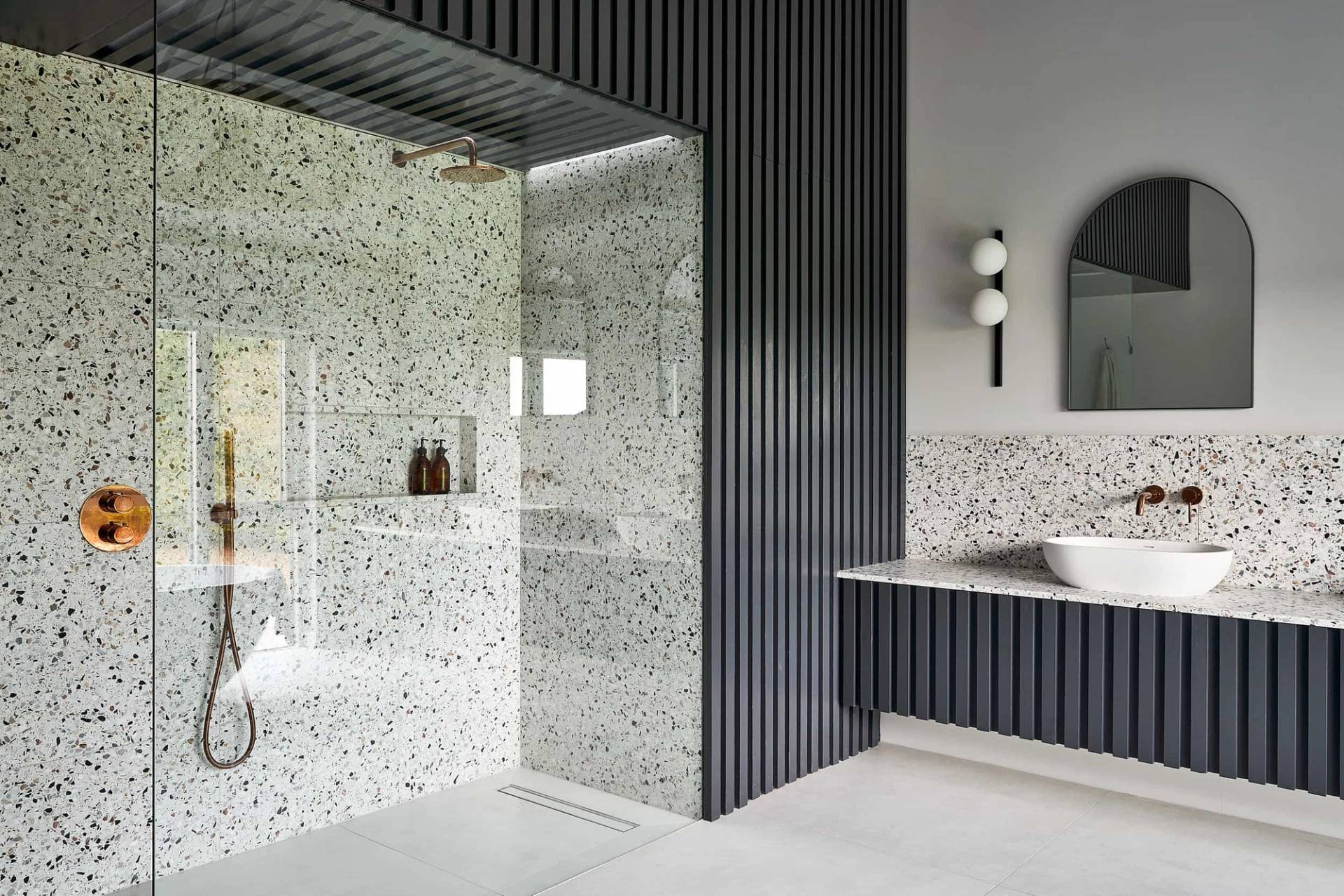 Spacious bathroom suite featuring a walk-in terrazzo shower enclosure and twin vanity sinks, Love Locations IP30.