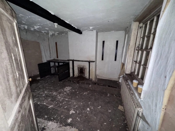 Grimy Victorian room with a simple fireplace hearth, old radiator, and soot-stained walls, a characterful filming location via Love Locations.