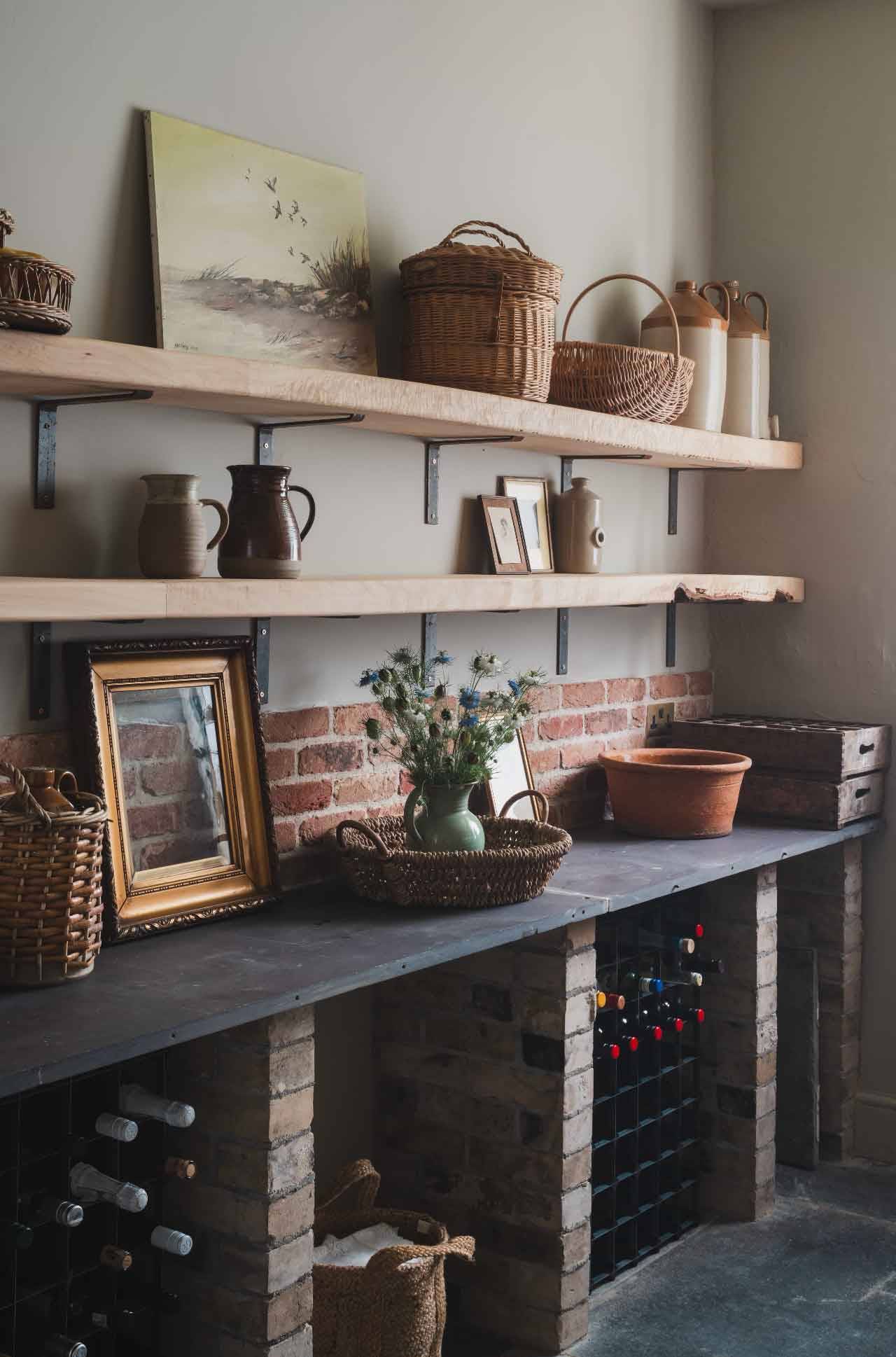 Rustic pantry or larder shoot space with open timber shelves and slate countertops in a Grade II-listed manor from Love Locations.