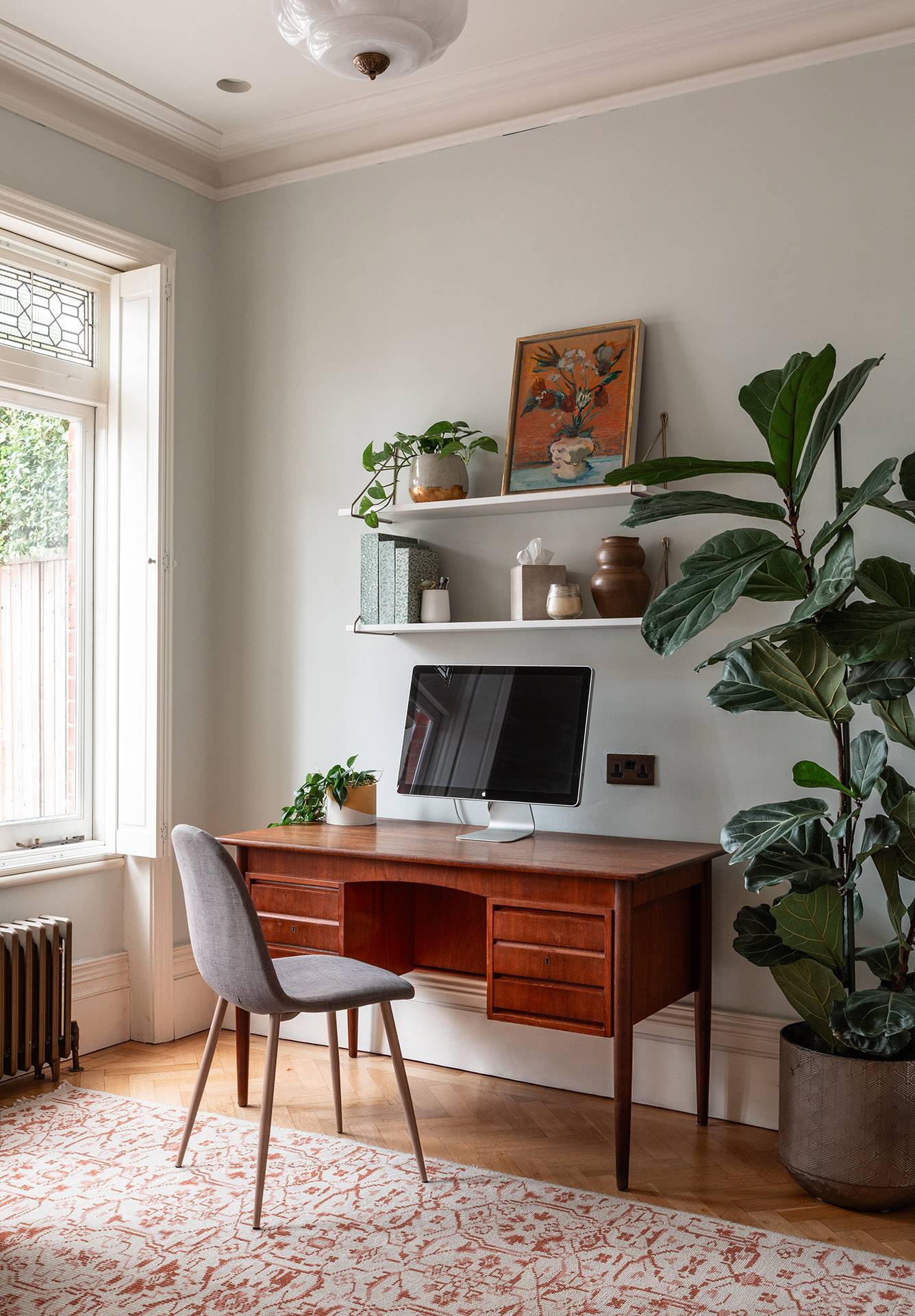 Minimalist home office setup featuring a mid-century wooden desk, desk lamp, and indoor plants, ideal for remote work lifestyle ads, Love Locations TW1.