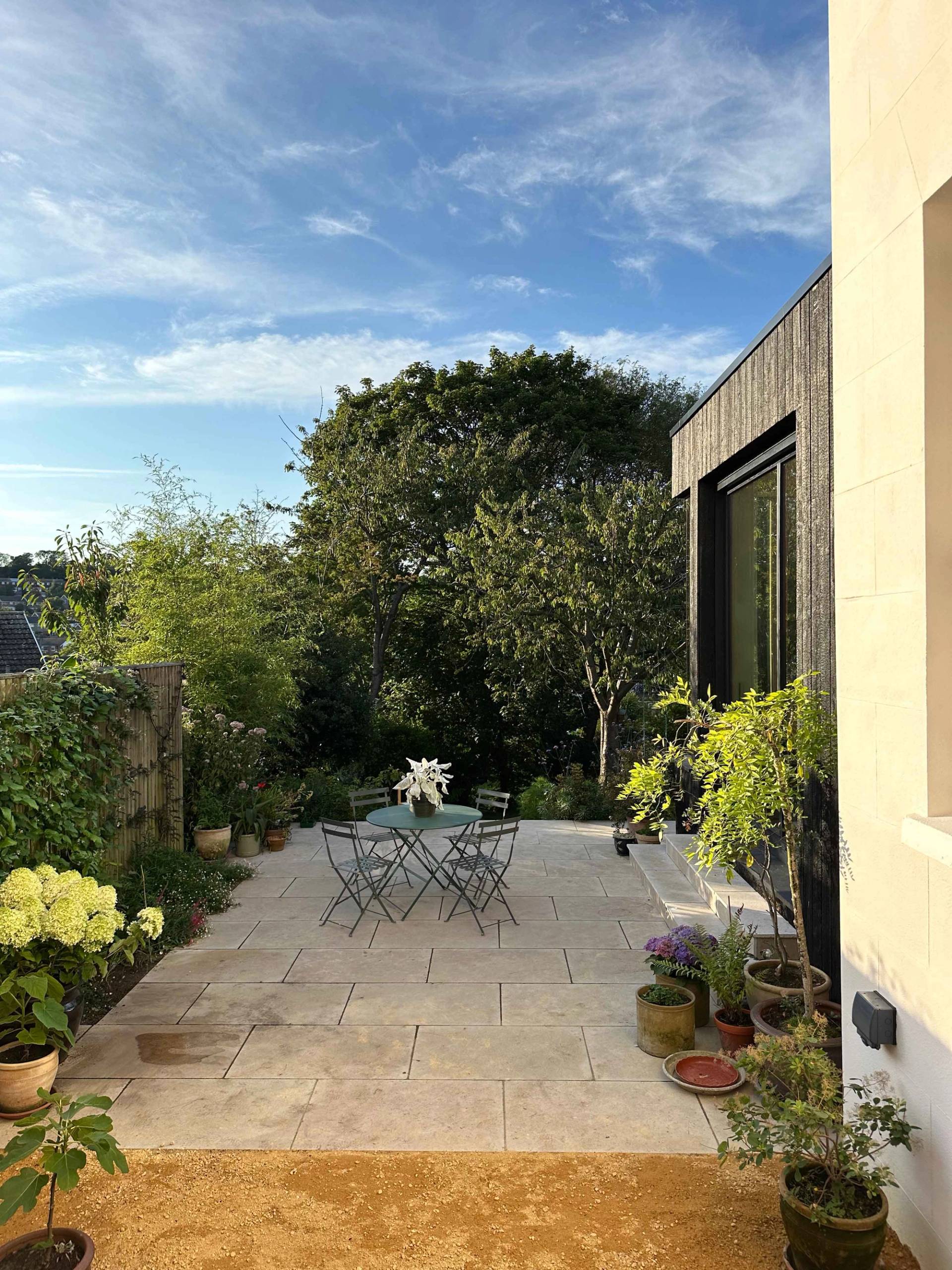 Elevated patio terrace overlooking a manicured lawn garden and modern timber extension, Love Locations.