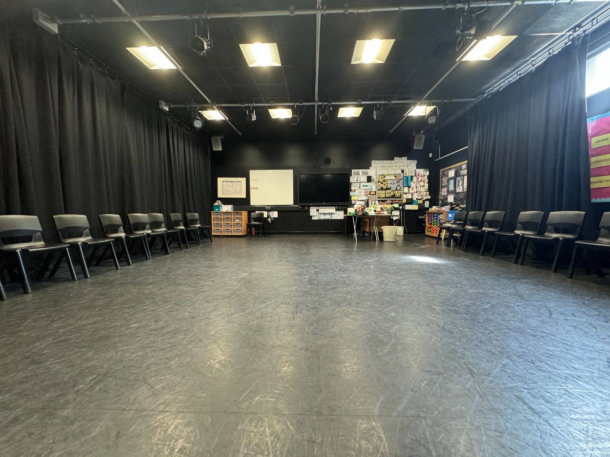 Rehearsal room and drama studio shoot space with black curtains, smooth flooring, and perimeter seating through Love Locations.