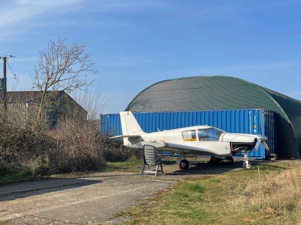 ￼Historic airfield shoot location in Corby, NN17 featuring vintage aircraft, open runways, and WWII structures, ideal for aviation film productions and music videos via Love Locations.