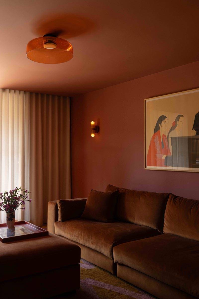 Moody terracotta-toned sitting room shoot venue in Boerum Hill Brooklyn NY 11217 from Love Locations, featuring a plush brown sofa, sheer drapes, and warm ambient lighting.