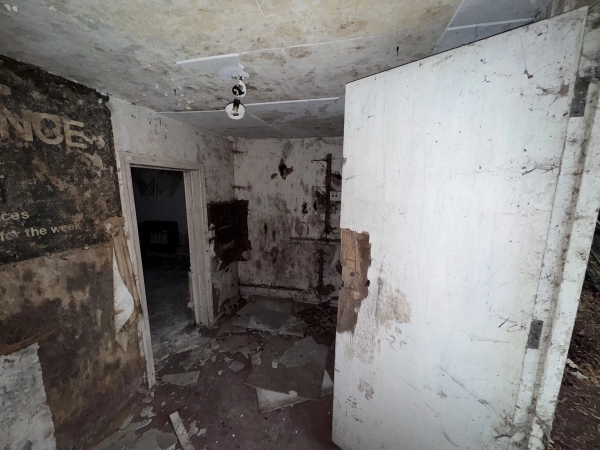 Derelict room with collapsed wall partitions, exposed wooden lath, and debris-covered floors for realistic disaster scene filming, Love Locations NG9.