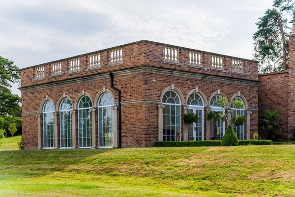 Stunning grand arched windows of a luxury orangery ballroom, perfect for high-end fashion shoots and product launches with Love Locations.