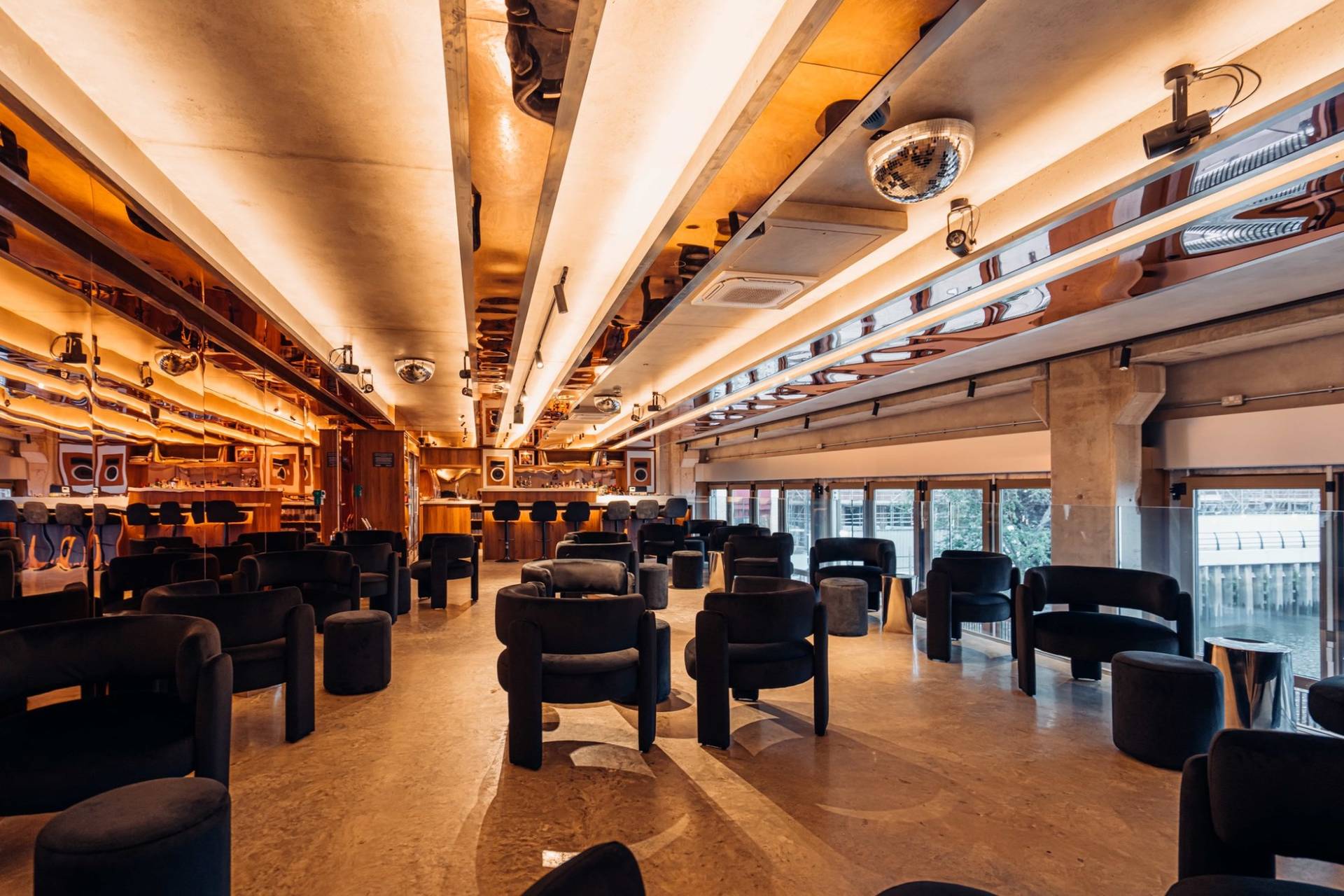 Luxurious listening bar lounge with plush dark armchairs and ambient strip ceiling lighting in Brentford TW8 via Love Locations.