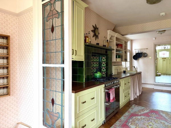 Art Nouveau stained glass door detail framing a period kitchen interior in Palmers Green, Love Locations N13.