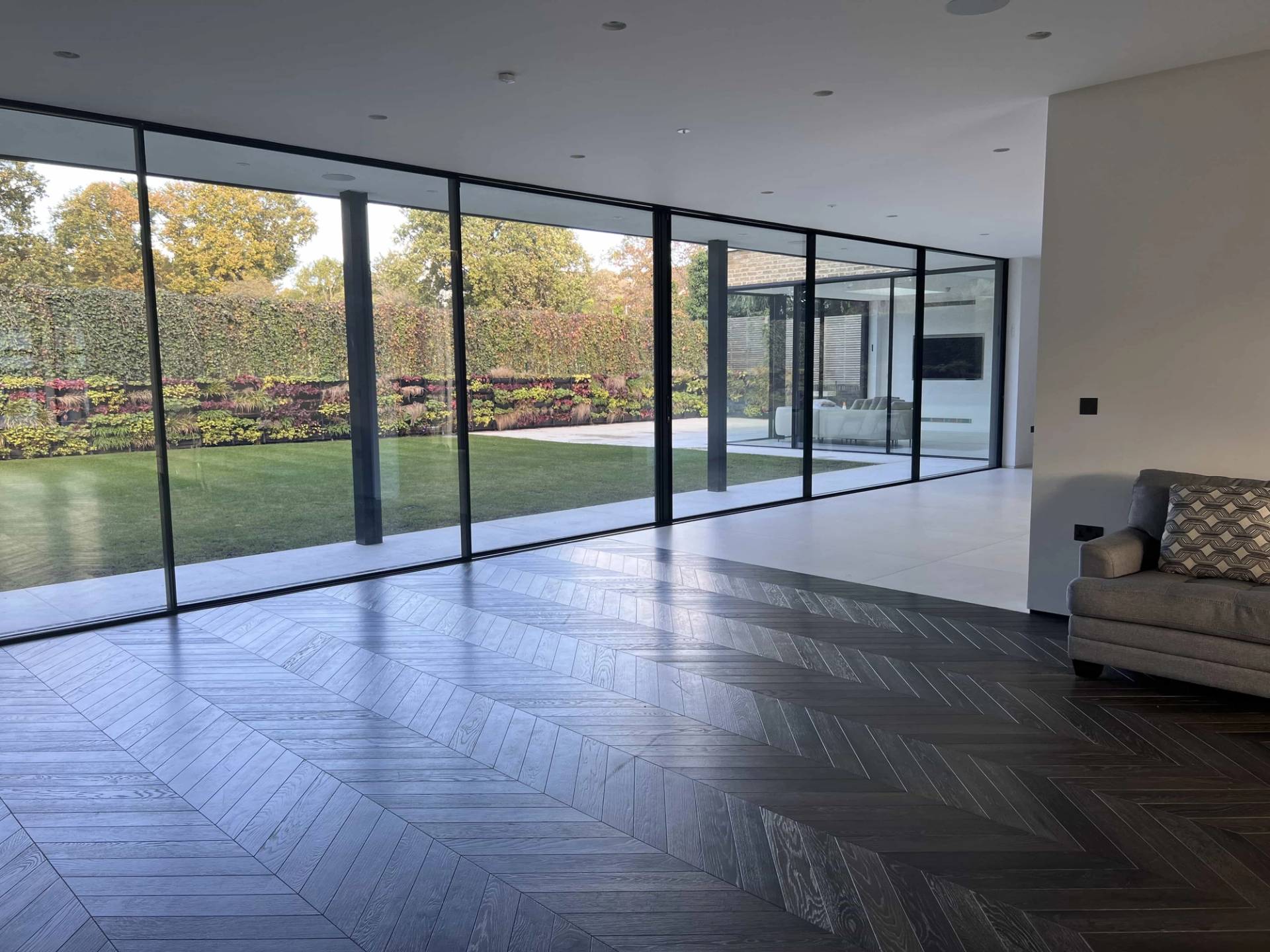 Wide-angle perspective of an open-plan lounge with full-width sliding glass patio doors, suitable for commercial furniture lookbooks, Love Locations.