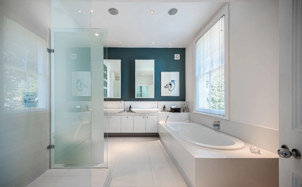 Spacious modern bathroom location in Chiswick, London W4 featuring a deep soaking tub, double sinks, and dark teal accent walls, perfect for skincare commercials via Love Locations.