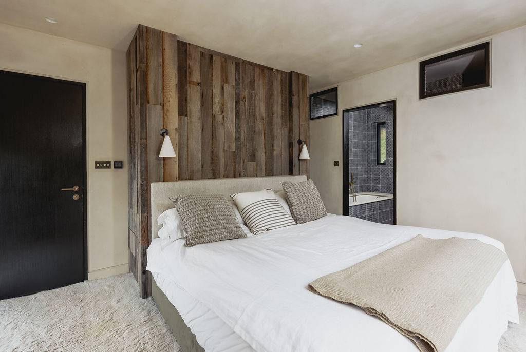 Double bedroom suite with upholstered fabric headboard, neutral bedding, and ensuite access, Love Locations GU32.
