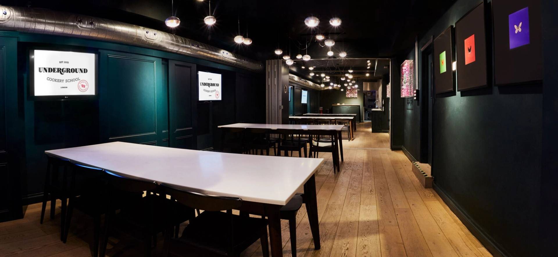 Moody, atmospheric private dining space with warm pendant lighting and wood flooring for corporate hospitality, Love Locations.