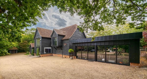 Rear view of barn-style house with gardens in Essex, Love Locations