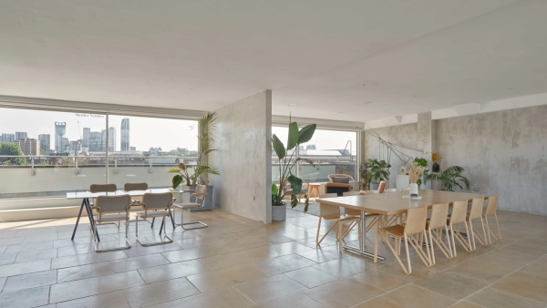 Modern London penthouse with floor-to-ceiling windows and city skyline view.