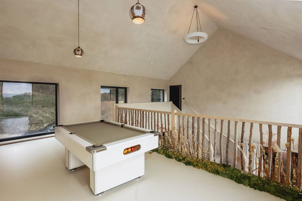 Mezzanine landing games room with a white pool table, rustic timber railings, and vaulted ceilings, Love Locations GU32.