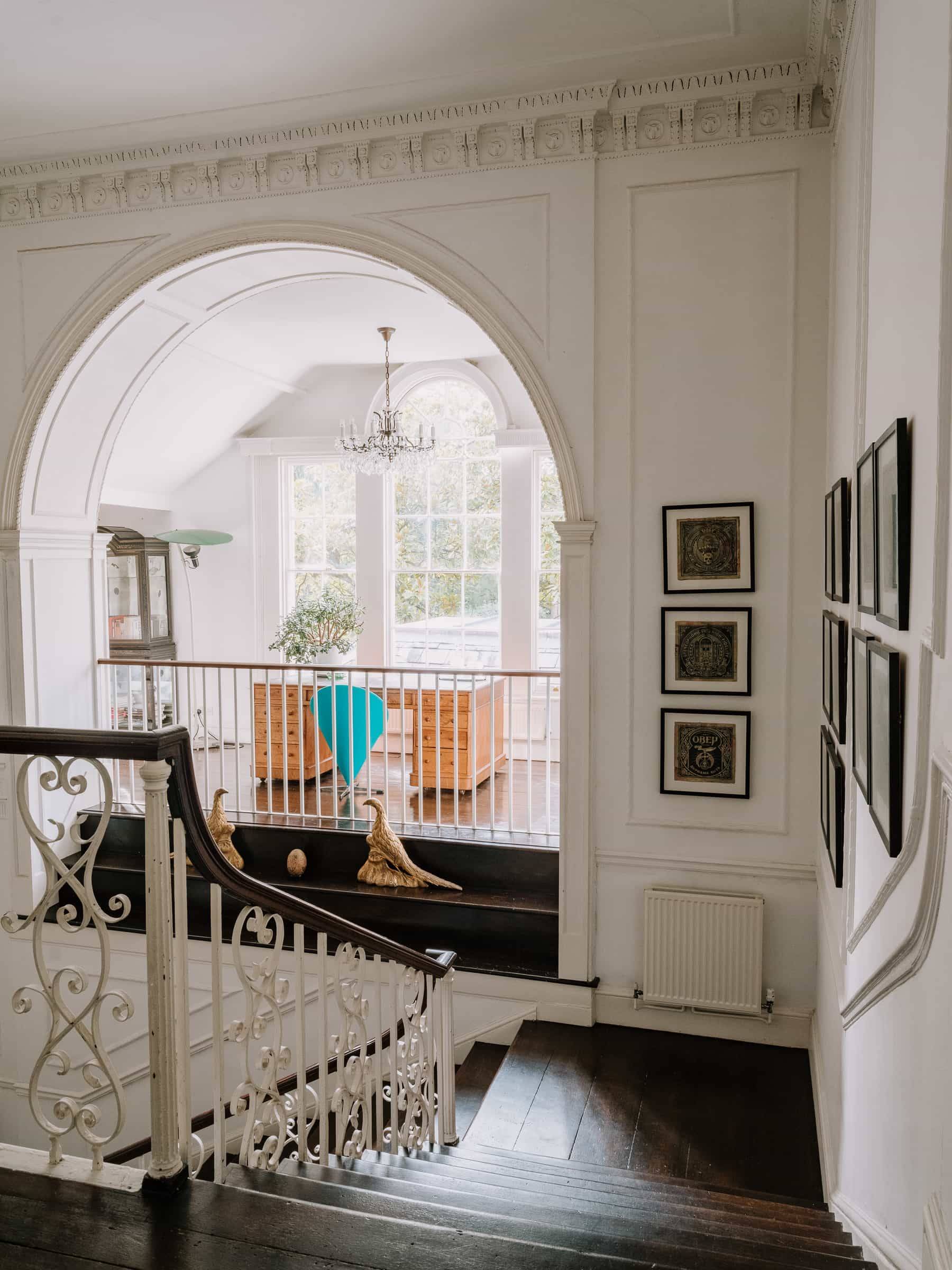 Upper landing gallery looking through an architectural archway down to a grand entrance hall, Love Locations RG42.