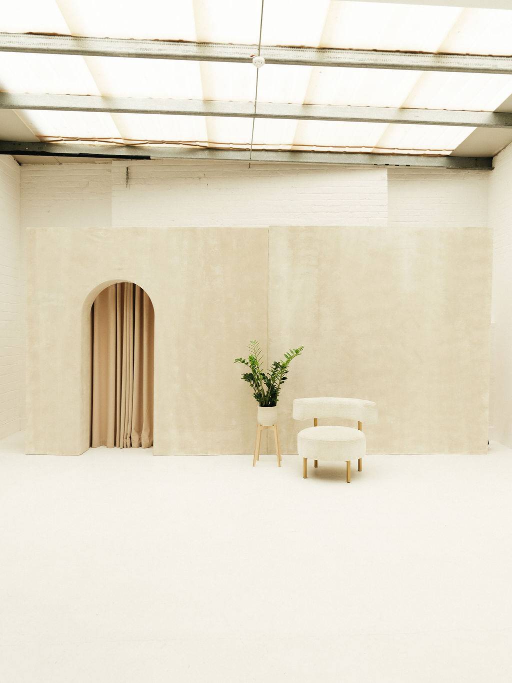 Romantic wedding backdrop with brushed plaster arched wall and curtain at Love Locations Brixton Warehouse.